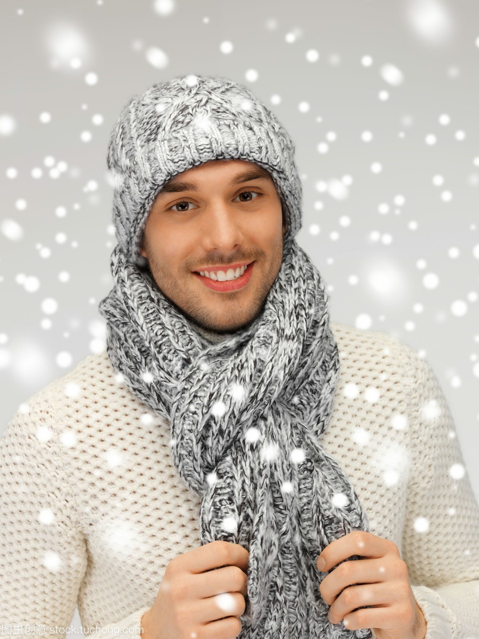 英俊的男人的照片在温暖的毛衣帽子和围巾。